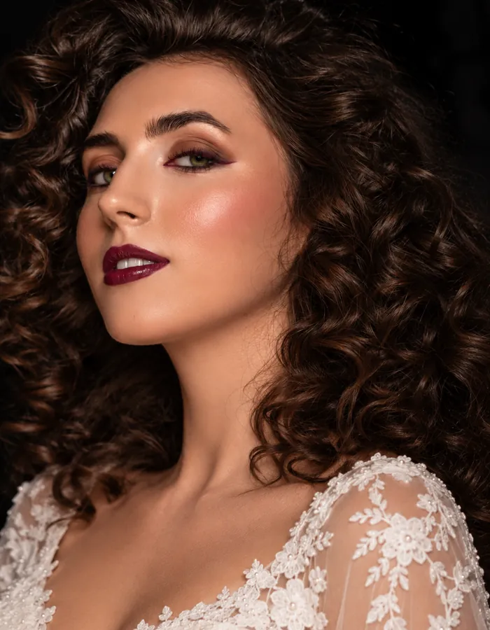Abend-Make-up mit Smokey Eyes, beerenroten Lippen und großen Locken